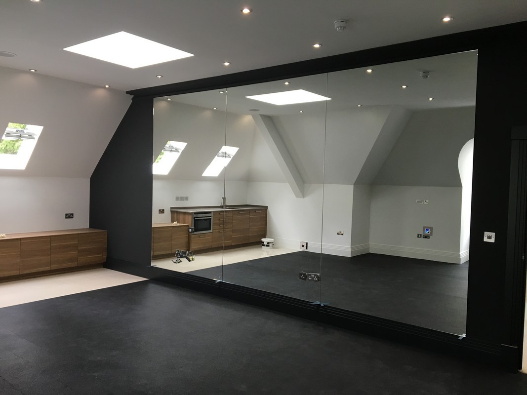 Frameless glass wall dividing loft conversion in St Albans